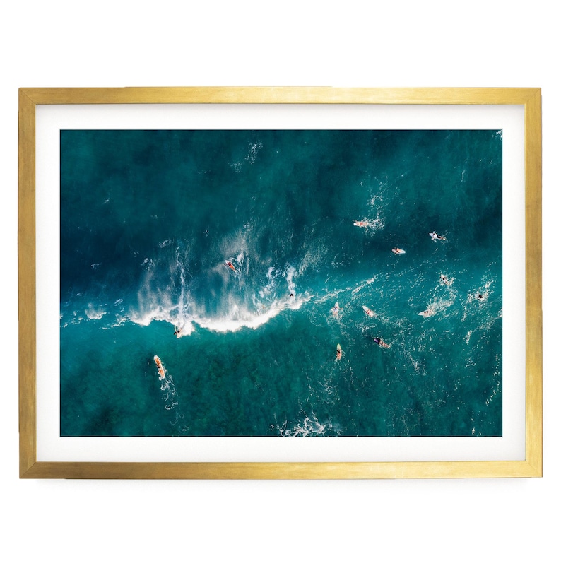 a group of people surfing on a large, turquoise ocean wave.