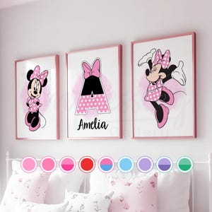 Könnte beinhalten: Drei gerahmte Wandbilder für ein Kinderzimmer mit Minnie Mouse und dem Buchstaben A. Die Minnie Mouse-Drucke zeigen sie in einem rosa gepunkteten Kleid und einer Schleife. Der Buchstabe A ist rosa gepunktet mit dem Namen "Amelia". Die Rahmen sind rosa.