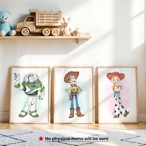 Peut inclure: Trois impressions encadr&eacute;es repr&eacute;sentant les personnages de dessins anim&eacute;s Buzz l'&Eacute;clair, Woody et Jessie de Toy Story. Les impressions sont affich&eacute;es sur un mur avec une &eacute;tag&egrave;re en bois contenant des jouets, dont un ours en peluche et un camion en bois.
