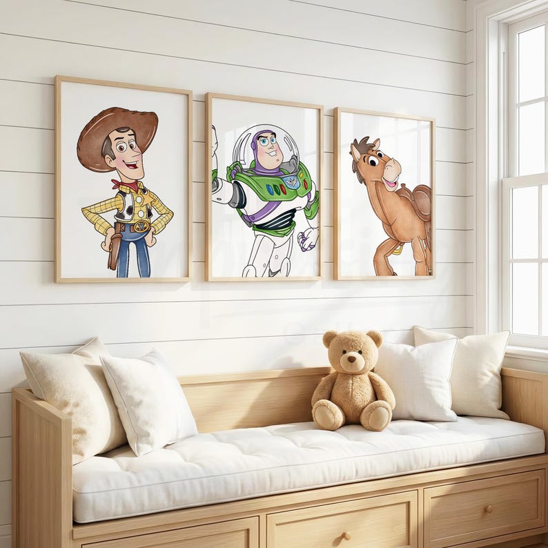 May include: Three framed watercolor prints featuring characters from the Toy Story movie. Woody, Buzz Lightyear, and Bullseye are depicted in a child's bedroom setting. A wooden bench with a white cushion and pillows is below the prints.