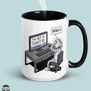 Peut inclure: Mug en céramique blanche avec intérieur et anse noirs. Illustration humoristique d'un robot aux prises avec un test CAPTCHA sur un écran d'ordinateur. Le texte sur l'écran indique "I'M NOT A ROBOT". Contenance de 444 ml.