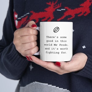 May include: White ceramic mug with a black outline of a ring and the text "There's some good in this world Mr Frodo, and it's worth fighting for."
