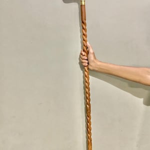 May include: A wooden walking stick with a twisted design and a brass dog head handle.