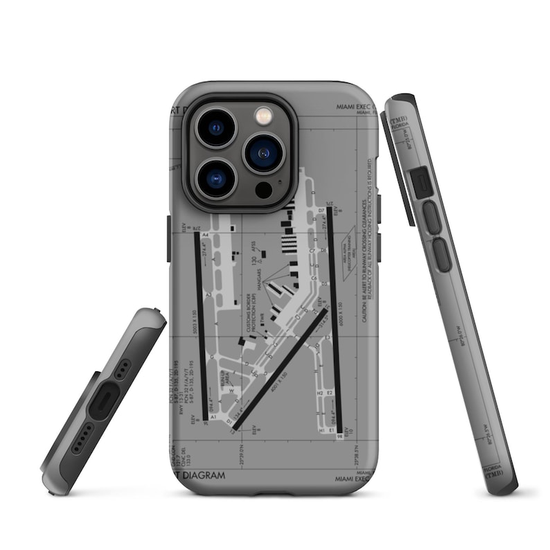 May include: A grey iPhone case featuring a printed map of Miami International Airport (MIA) on the back. The case has a cut-out for the camera lens and a raised edge to protect the screen.