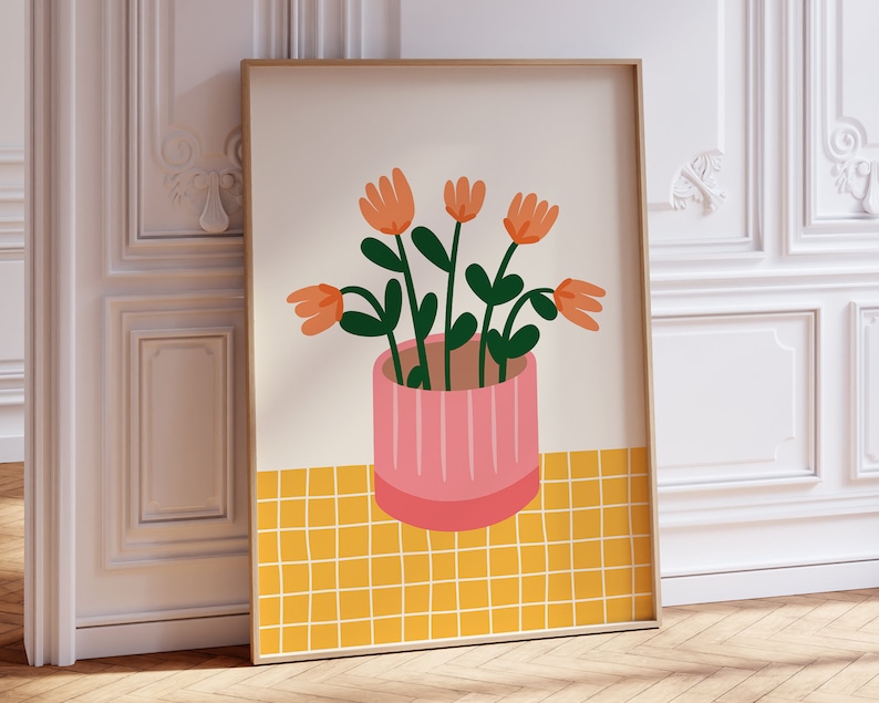 May include: A framed print of a stylized illustration of a potted plant with orange flowers and green leaves on a yellow tiled background.