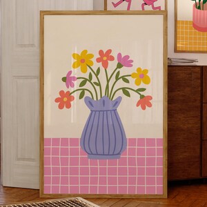 May include: A colorful floral arrangement in a blue vase with a pink and white checkered background. The flowers are yellow, pink, orange, and red.