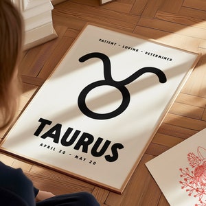 May include: A white poster with black text and a black Taurus zodiac symbol. The text reads "Patient - Loving - Determined" and "Taurus April 20 - May 20".