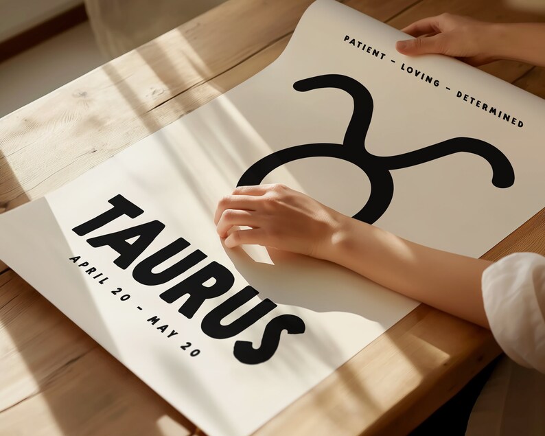 May include: A white poster with the word "Taurus" in black bold letters and the dates "April 20 - May 20" printed below. The Taurus zodiac symbol is printed in black above the word "Taurus". The text "Patient - Loving - Determined" is printed in black at the top right corner of the poster.