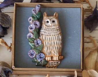 Owl brooch pin. Ceramic eagle owl sits on a branch with blue flowers. Pottery brooch eagle-owl.