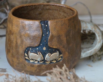 Handmade ceramic mug with bunnies sleeping in a hole. Ceramic animal cup. Forest mug with a hare, a cozy cup of hygge