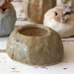 Steinförmiger Übertopf aus Keramik für Sukkulenten und Kakteen. Grüner mini handgemachter Übertopf.