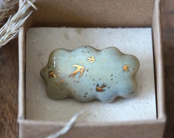 Ceramic pin brooch blue cloud with golden swallows. Ceramic jewelry by Svetlana Solovaya