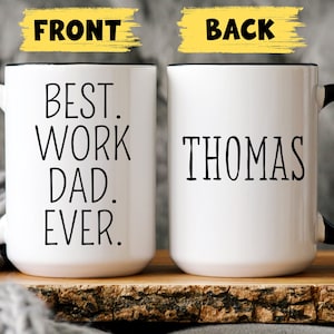 May include: White ceramic mug with a black handle. The front of the mug reads "Best. Work Dad. Ever." The back of the mug reads "Thomas".