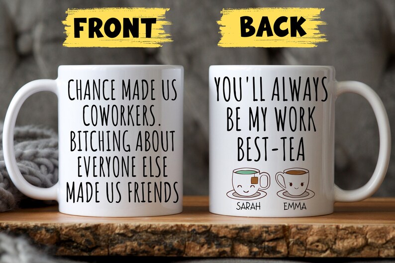 May include: Two white coffee mugs with black text. The front mug reads "Chance made us coworkers. Bitching about everyone else made us friends." The back mug reads "You'll always be my work best-tea" with two cartoon teacups with the names "Sarah" and "Emma" underneath.