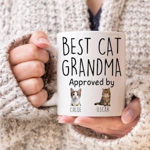 May include: White ceramic mug with black text that reads "Best Cat Grandma Approved by" with two cat photos below the text. The cat photos are labeled "Chloe" and "Oscar".