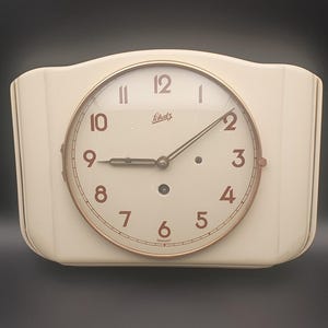 Puede incluir: Un juego de tres tazas de cerámica con un esmalte moteado de color crema. Cada taza presenta un diseño pintado a mano diferente: una hoja azul y verde, una flor amarilla y una baya roja. Las tazas tienen una forma simple y redondeada.