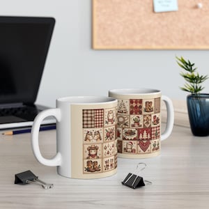 May include: Two white ceramic mugs featuring a repeating grid pattern of small square illustrations. The designs include cowboy-themed elements like boots, hats, horses, and festive holiday motifs such as Christmas trees and ornaments.