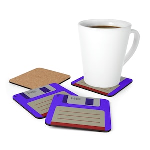 Könnte beinhalten: Vier Untersetzer mit einem Retro-Floppy-Disk-Design. Die Untersetzer sind lila mit einem grauen und roten Floppy-Disk-Design. Der Text "ME" ist auf der Diskette gedruckt. Eine weiße Kaffeetasse steht auf einem der Untersetzer.