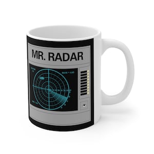 May include: White ceramic mug with a black and gray design featuring a radar screen with the text "MR. RADAR".