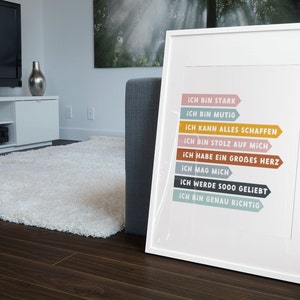 May include: A white framed print with colorful arrows and the text "ICH BIN STARK", "ICH BIN MUTIG", "ICH KANN ALLES SCHAFFEN", "ICH BIN STOLZ AUF MICH", "ICH HABE EIN GROBES HERZ", "ICH MAG MICH", "ICH WERDE SOOO GELIEBT", "ICH BIN GENAU RICHTIG".
