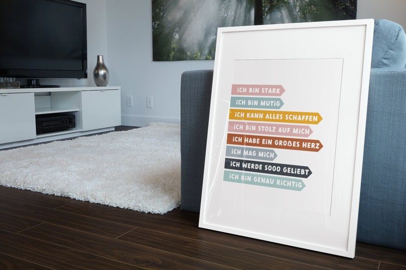 May include: A white framed print with colorful arrows and the text "ICH BIN STARK", "ICH BIN MUTIG", "ICH KANN ALLES SCHAFFEN", "ICH BIN STOLZ AUF MICH", "ICH HABE EIN GROBES HERZ", "ICH MAG MICH", "ICH WERDE SOOO GELIEBT", "ICH BIN GENAU RICHTIG".