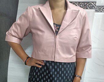 May include: A pink cropped leather jacket with a zipper closure and a collar. The jacket has three-quarter sleeves.