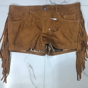 K&ouml;nnte beinhalten: Braune Wildleder-Shorts mit Fransenbesatz. Die Shorts haben eine vordere Tasche und eine hintere Tasche.