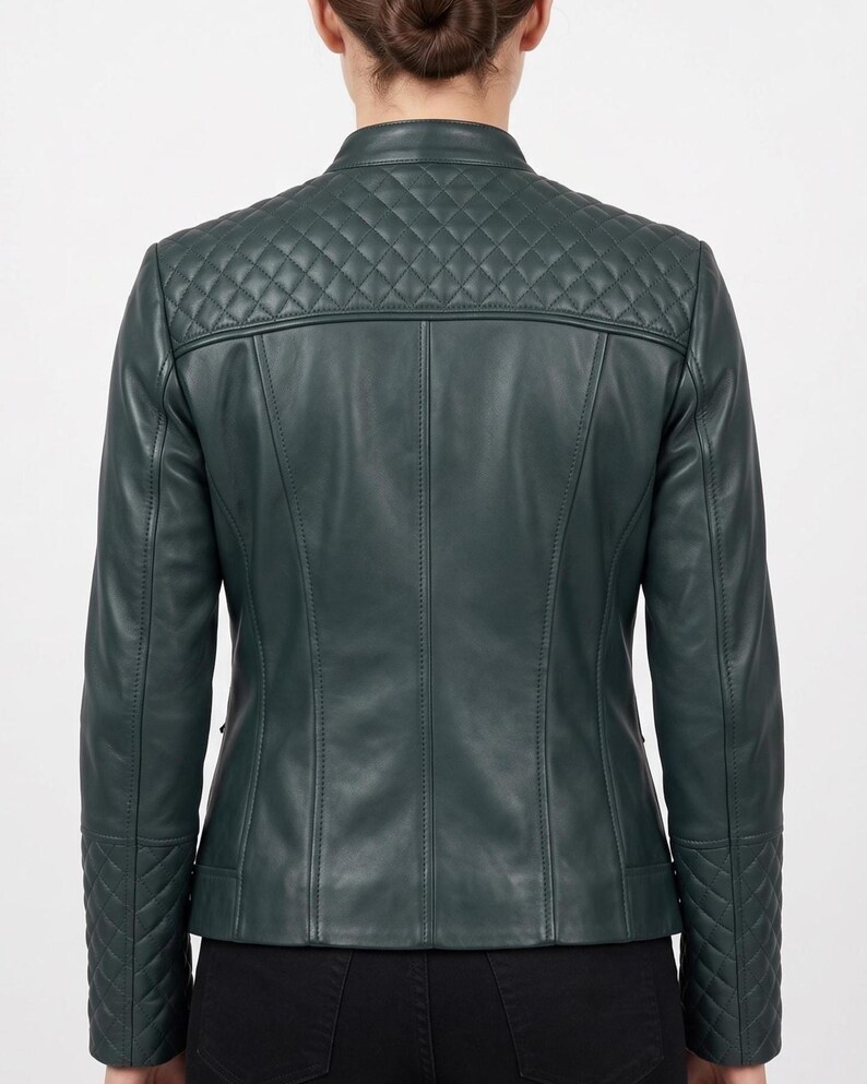 May include: A dark green jacket featuring a mandarin collar and a quilted diamond pattern across the upper back and shoulders. The long sleeves include matching quilted diamond detailing at the cuffs, with vertical seam lines along the back panel.