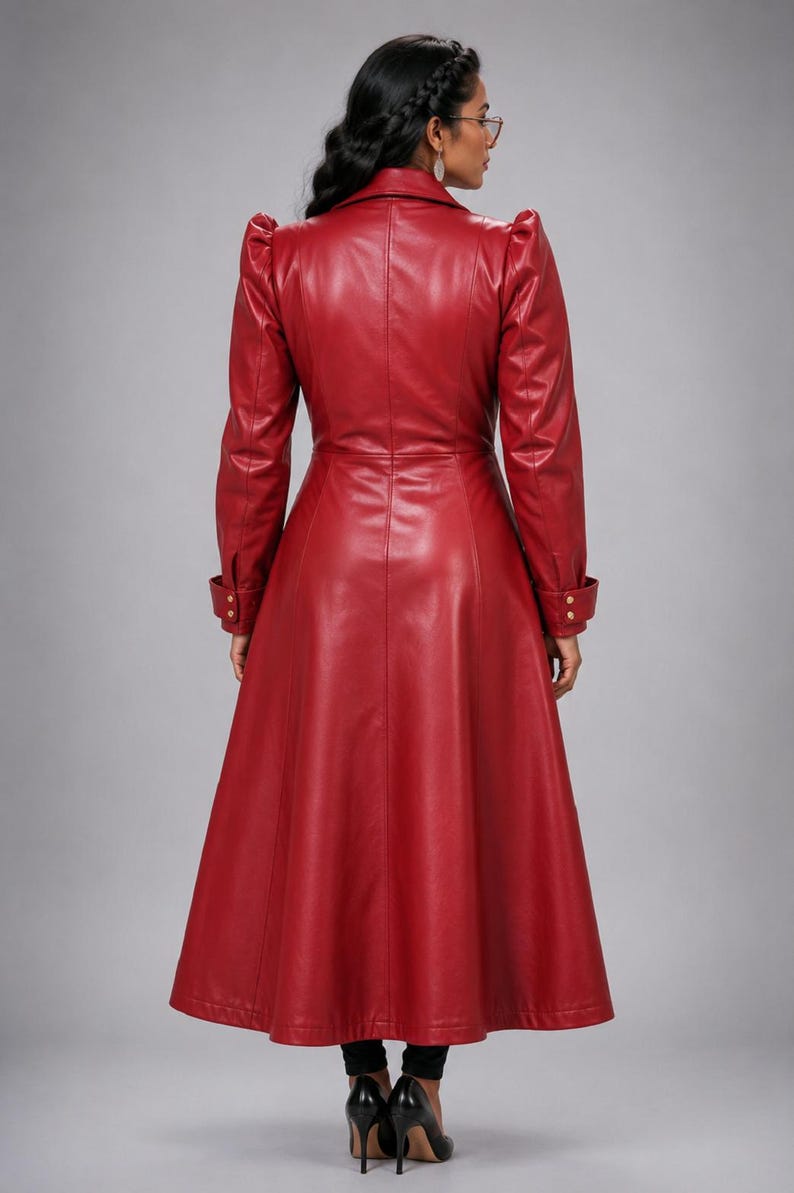 May include: A long, deep red coat with a smooth finish, featuring a structured collar, puffed shoulders, and long sleeves with buttoned cuffs. The coat has a fitted bodice that flares into a full-length skirt, creating a sleek, tailored silhouette.