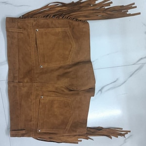 K&ouml;nnte beinhalten: Braune Wildleder-Shorts mit Fransen. Die Shorts haben zwei Ges&auml;&szlig;taschen und einen Knopfverschluss.