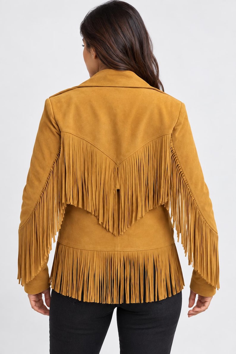 May include: A mustard yellow jacket featuring long fringe detailing across the back, shoulders, and hemline. The jacket has a collared neckline and long sleeves, with the fringe extending from the upper back yoke down to the lower hem.