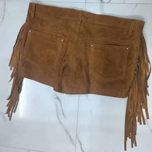 K&ouml;nnte beinhalten: Braune Wildleder-Shorts mit Fransenbesatz. Die Shorts haben zwei Vordertaschen und zwei Ges&auml;&szlig;taschen.