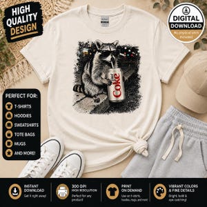 May include: Cream-colored t-shirt featuring a raccoon wearing sunglasses and drinking from a Diet Coke can. The graphic is in black and white. The shirt is displayed with gray sweatpants, a baseball cap, and white sneakers. Text on the shirt says "Diet Coke".