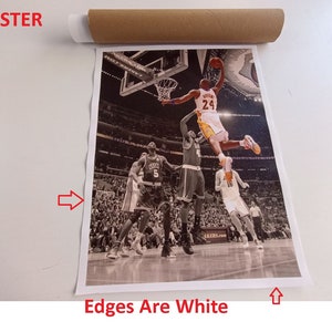 May include: A black and white poster featuring a basketball player in mid-air, dunking the ball. The player is wearing a yellow jersey with the number 24 on it. The poster has white edges.