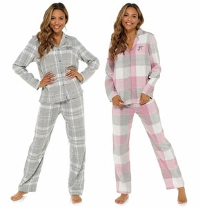 Puede incluir: Dos pijamas con estampado de cuadros. Un par es gris y blanco, el otro es rosa y blanco. Ambos pares tienen mangas largas y pantalones largos.
