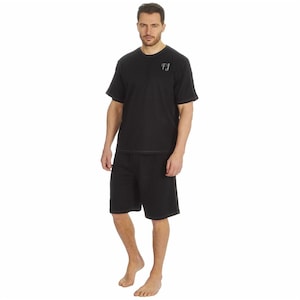 May include: Black short-sleeved pajama top and matching shorts. The top has the initials "FJ" embroidered on the chest.