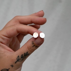 May include: A pair of silver stud earrings with a hammered finish.
