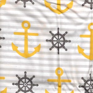 May include: A white and gray striped fabric with a repeating pattern of yellow anchors and gray ship wheels.