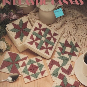 May include: A Leisure Arts craft leaflet titled Patchwork Coasters in Plastic Canvas, featuring instructions for six square coasters with geometric patterns in cream, maroon, and sage green, plus a matching square storage box for the set.