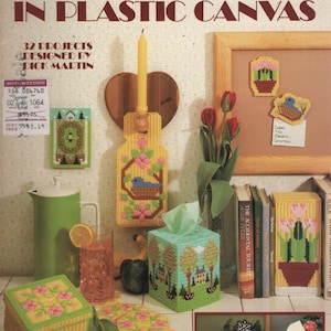 May include: A Leisure Arts craft leaflet titled Four Seasons in Plastic Canvas, featuring 32 projects by Dick Martin. The cover displays various plastic canvas items including a tissue box cover, a wall hanging, and coasters with seasonal motifs.