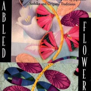 May include: A book cover titled "Fabled Flowers" by Kumiko Sudo. The cover features a colorful quilt design with pink, orange, and blue flower shapes. The text reads "Innovative Quilt Patterns Inspired by Japanese Sashiko and Origami Traditions."