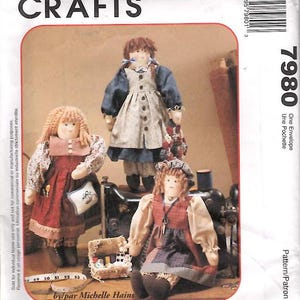 May include: Sewing pattern for two dolls, called "The Sewing Sisters". The dolls are dressed in vintage-style dresses with floral patterns. The pattern is by Michelle Hains and is for dolls that are 18 inches tall.