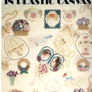 May include: A craft leaflet titled Victorian Magnets in Plastic Canvas featuring various needlepoint designs including floral baskets, picture frames, a swan, a parasol, and a lamp, all crafted from white plastic canvas with colorful yarn accents.