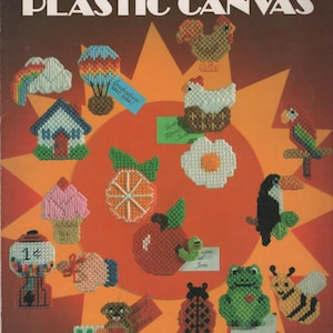 May include: A Leisure Arts craft leaflet titled Quick & Easy Magnets for Plastic Canvas, featuring 19 colorful needlepoint designs including a rainbow, hot air balloon, house, ice cream, gumball machine, fruit, animals, and insects on a sunburst background.