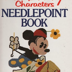May include: A white book titled Walt Disney Characters Needlepoint Book. The cover features a needlepoint illustration of Mickey Mouse holding a needle and thread, wearing a red hat, blue pants with yellow dots, and red shoes, with yellow flowers.