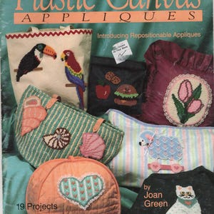 May include: A Pat Depke Books craft instruction book titled Plastic Canvas Appliques featuring 19 projects. The cover displays various items decorated with plastic canvas needlepoint designs, including a toucan, parrot, seashells, food, tulips, a sheep, a heart, and a cat.