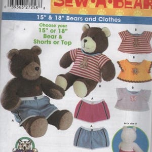 May include: A Simplicity Sew-A-Bear sewing pattern envelope for 15-inch and 18-inch bears and clothes. The package features illustrations of brown teddy bears wearing striped shirts and shorts, along with various clothing options and a back view.