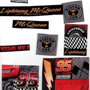May include: A collection of assorted stickers featuring Lightning McQueen, the number 95, Piston Cup logos, and racing themes. A wooden ruler is visible at the bottom, showing a length of 5 inches. The stickers include text like SPEED, NITROADE, and RE-VOLTING.