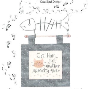 May include: A cross-stitch design featuring a fish skeleton and a banner that reads "Cat Hair... just another specialty fiber." The banner has a cat face and is on a gray patterned background. The design includes the text "My Big Toe Cross-Stitch Designs."