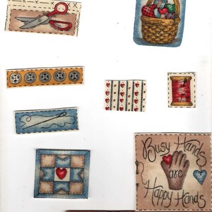 May include: A collection of craft-themed stickers featuring a ruler, scissors, buttons, a needle and thread, a quilt block, a basket of hearts, and a square sign with the text Busy Hands are Happy Hands, alongside a 5-inch wooden ruler.